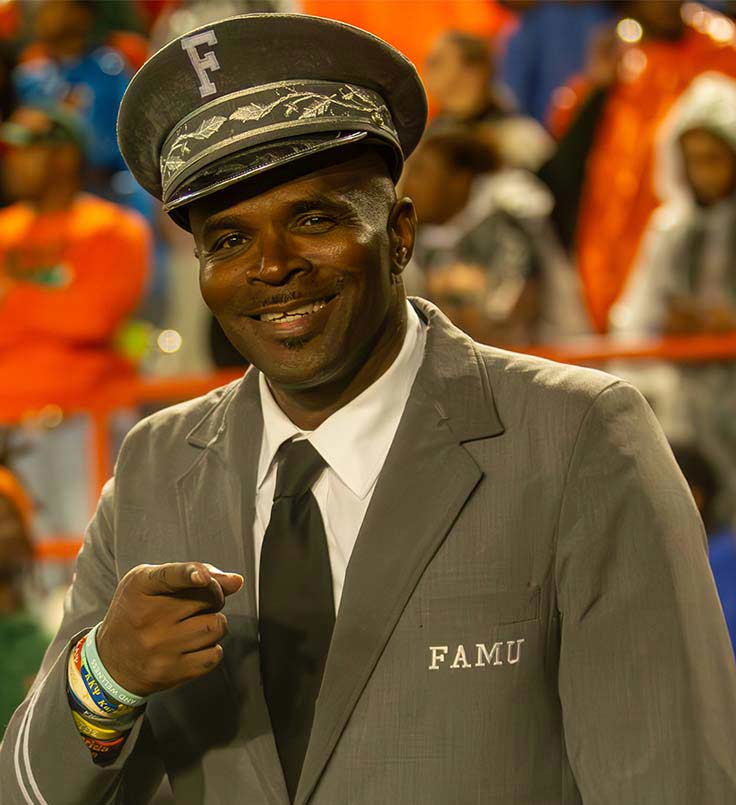 man on the field pointing at the camera with a grey famu sports coat