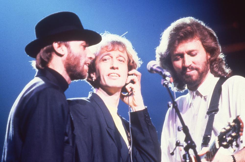Three men around a microphone