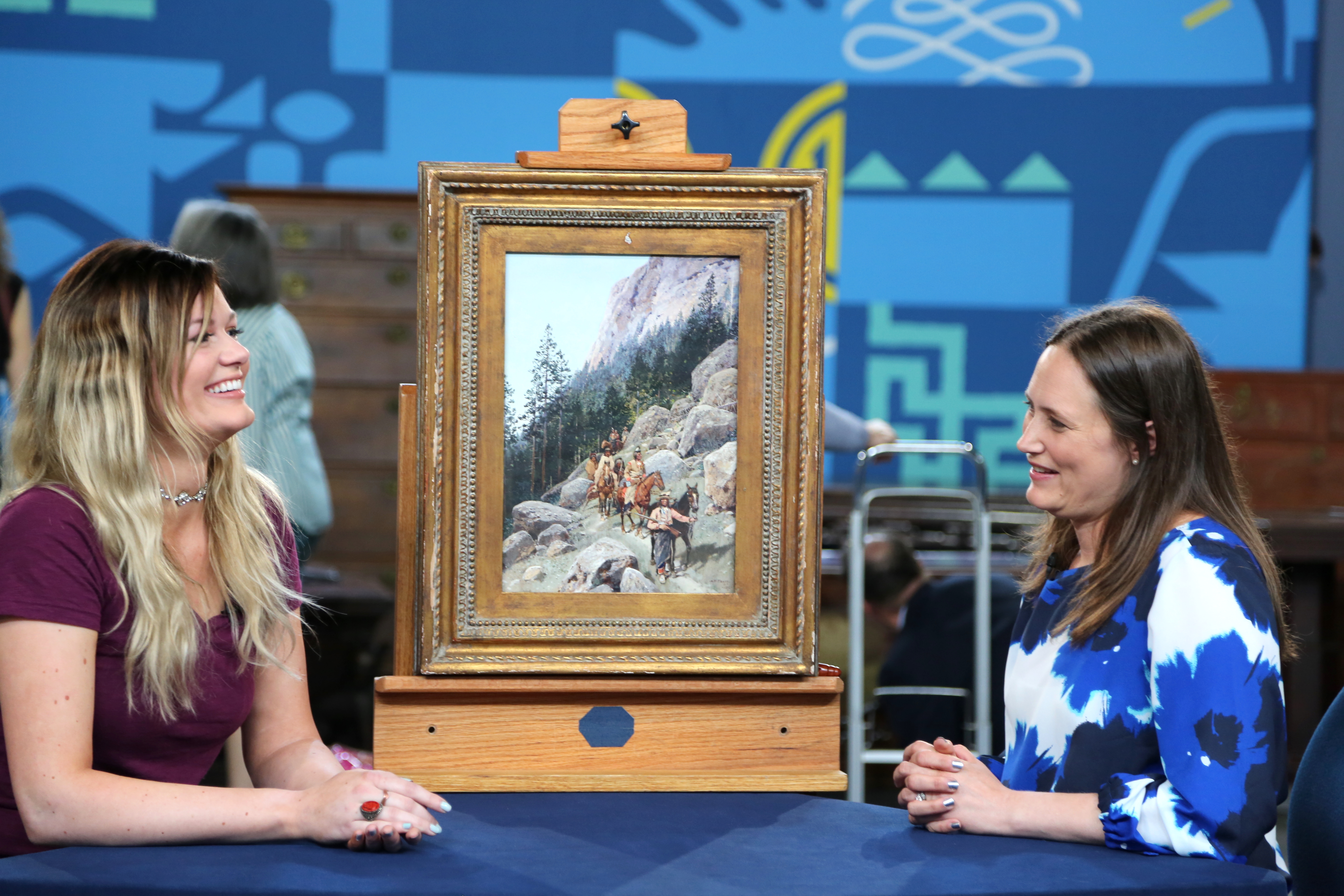 Two women on either side of a painting