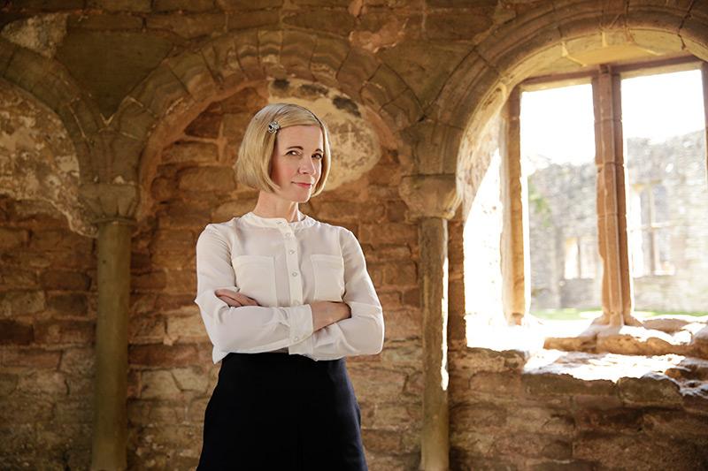 lucy crossing arms in a stone tower